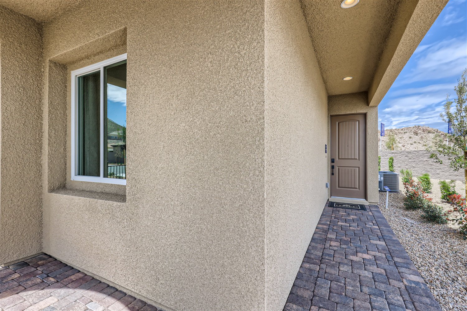A stone walkway with a door and windows.