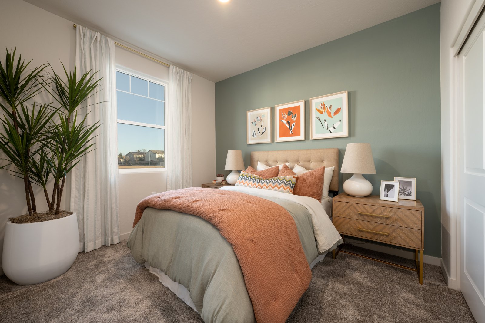 A bedroom with a bed and a plant.