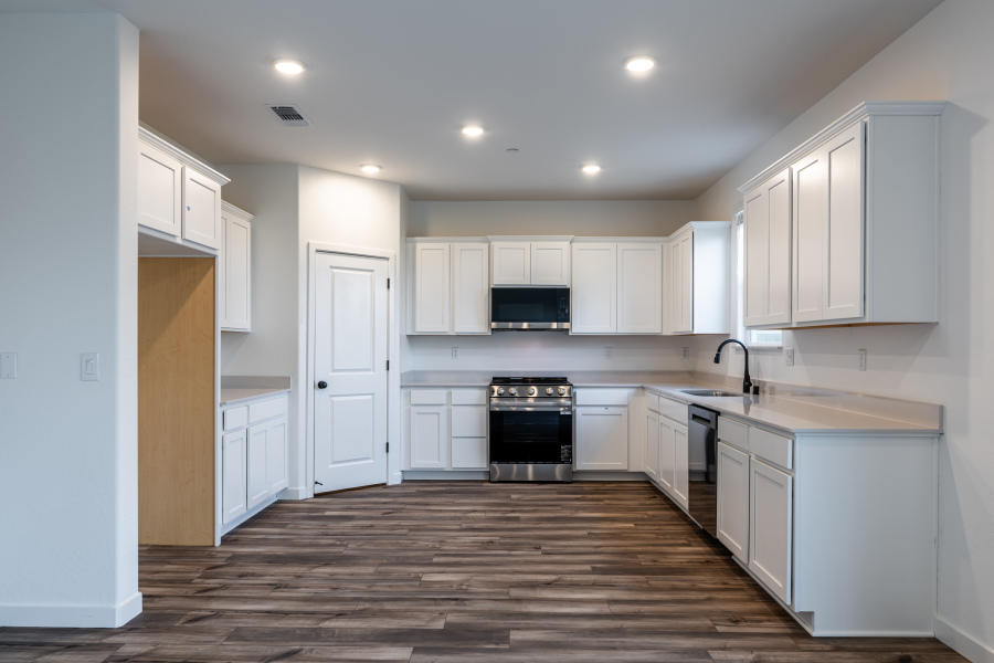 A kitchen with white cabinets.