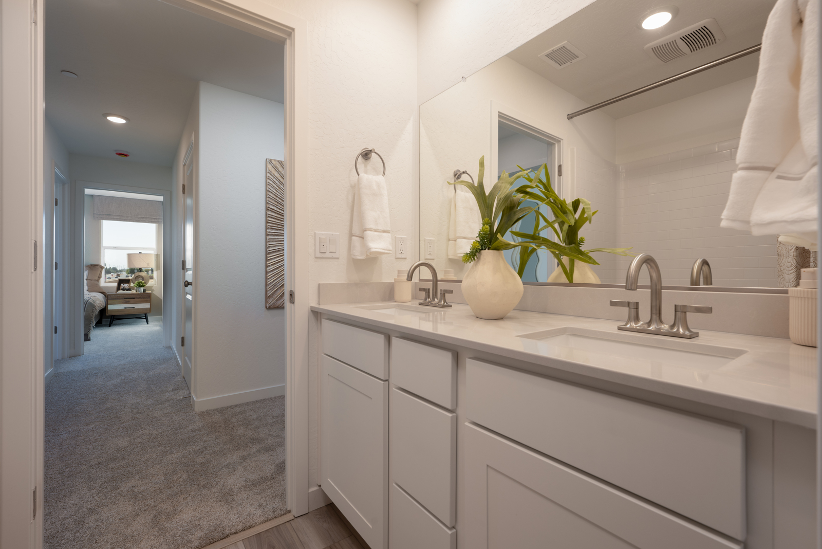 A bathroom with white cabinets.