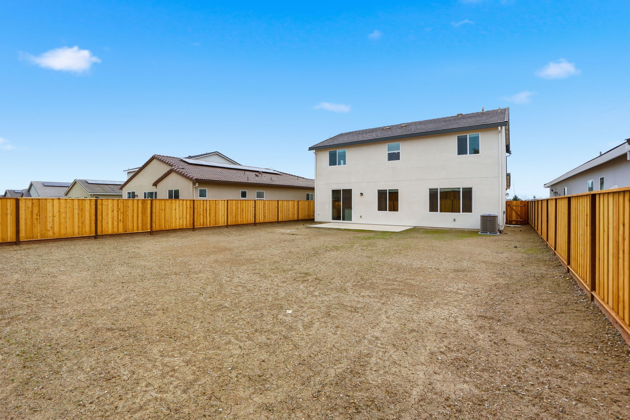 A dirt field with buildings in the background.