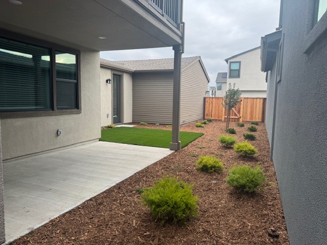 A backyard with a fence and a small garden.