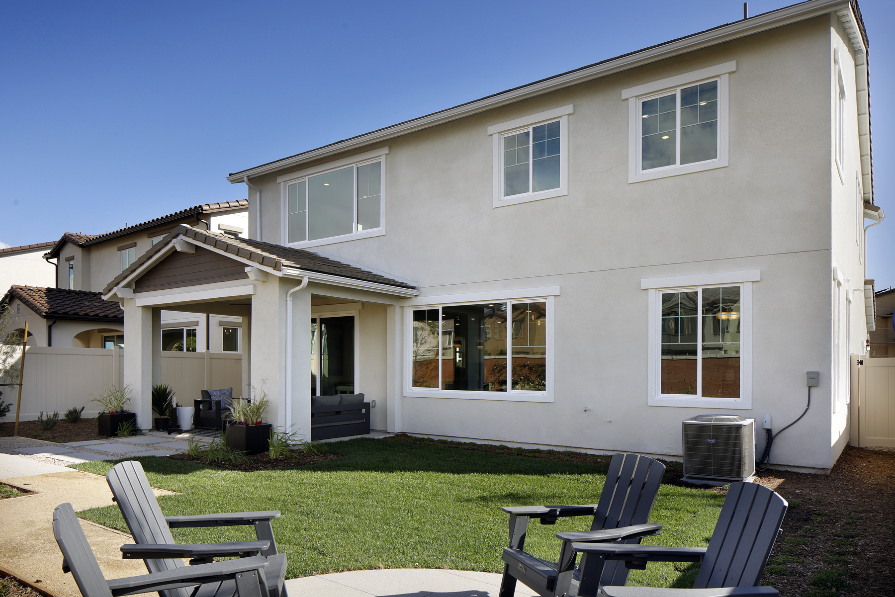 A house with a lawn and chairs.
