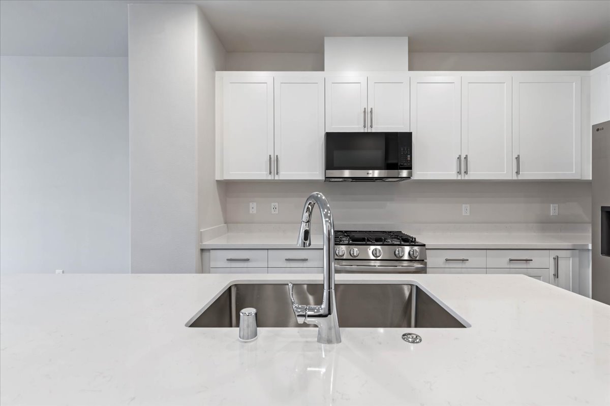 A kitchen with white cabinets.