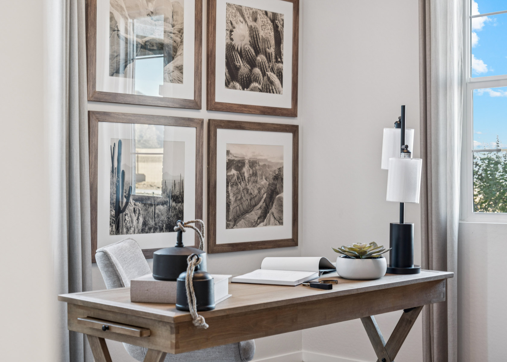 A table with a lamp and a window with pictures on it.