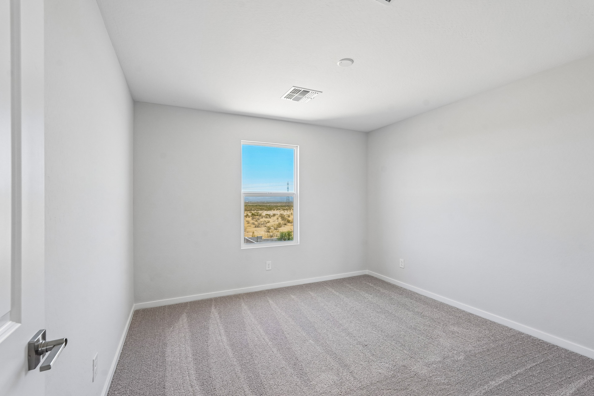 A room with a window and a carpet.