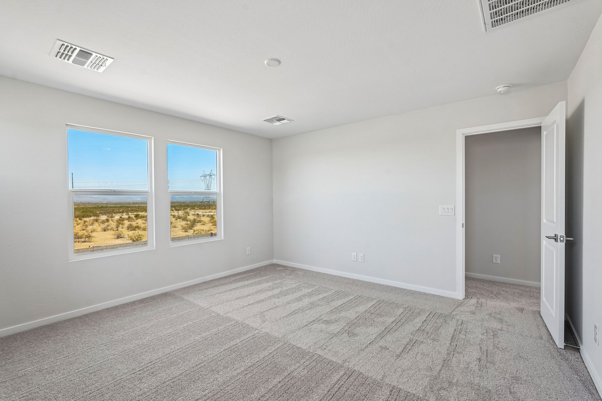 A room with a carpet and windows.