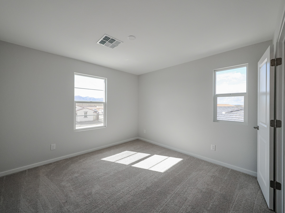 A room with a rug and windows.