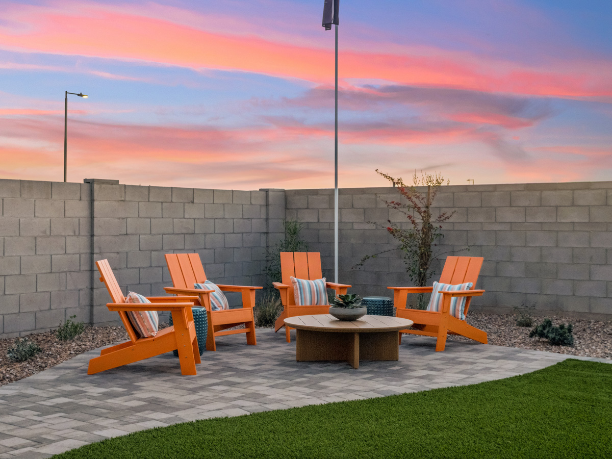A group of chairs around a table outside.