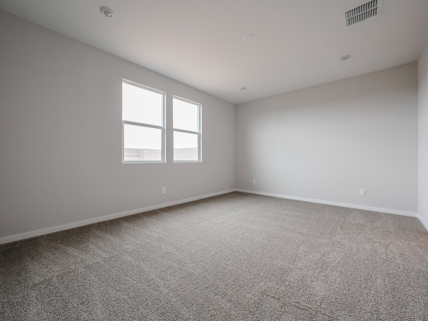 A room with a carpet and windows.