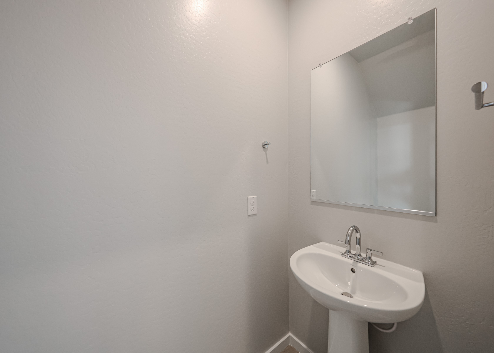 A bathroom with a mirror and sink.