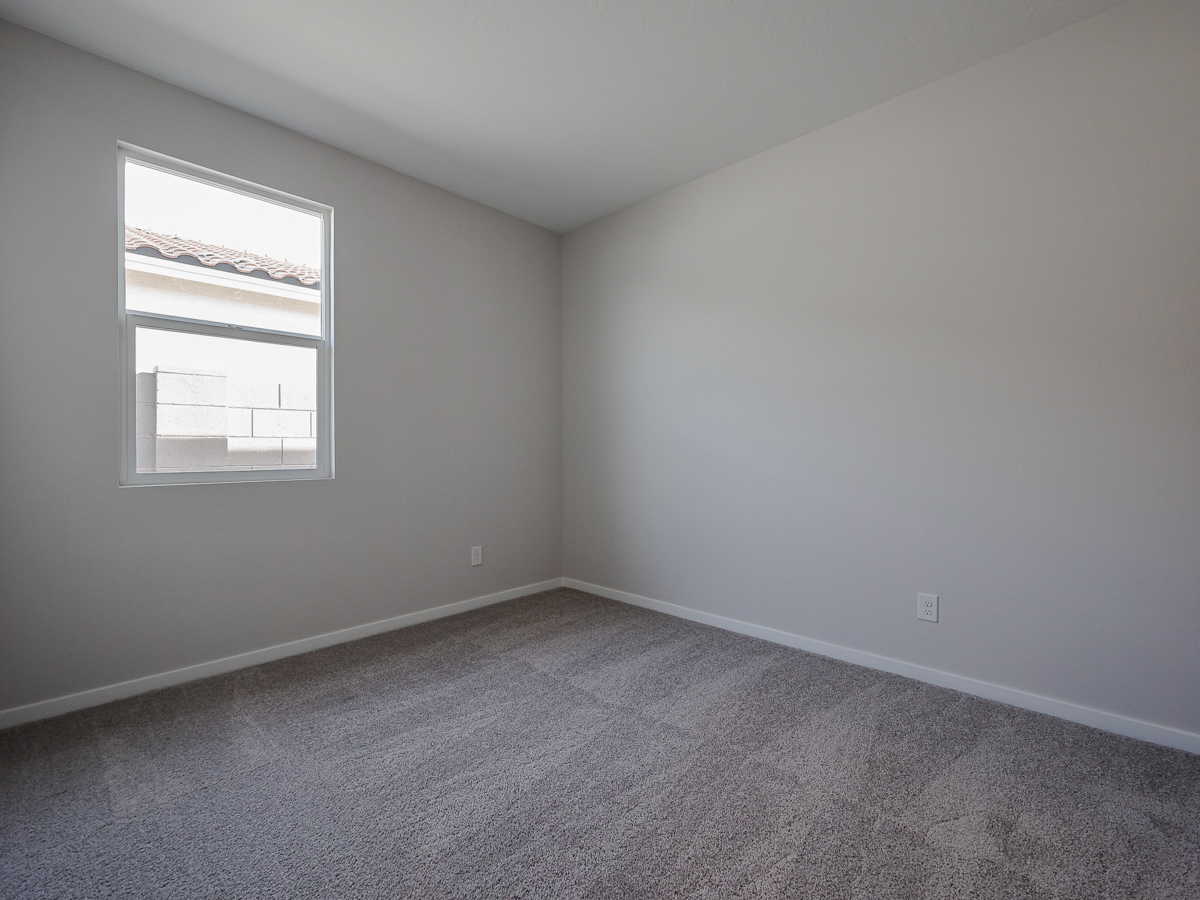 A room with a window and a carpet.