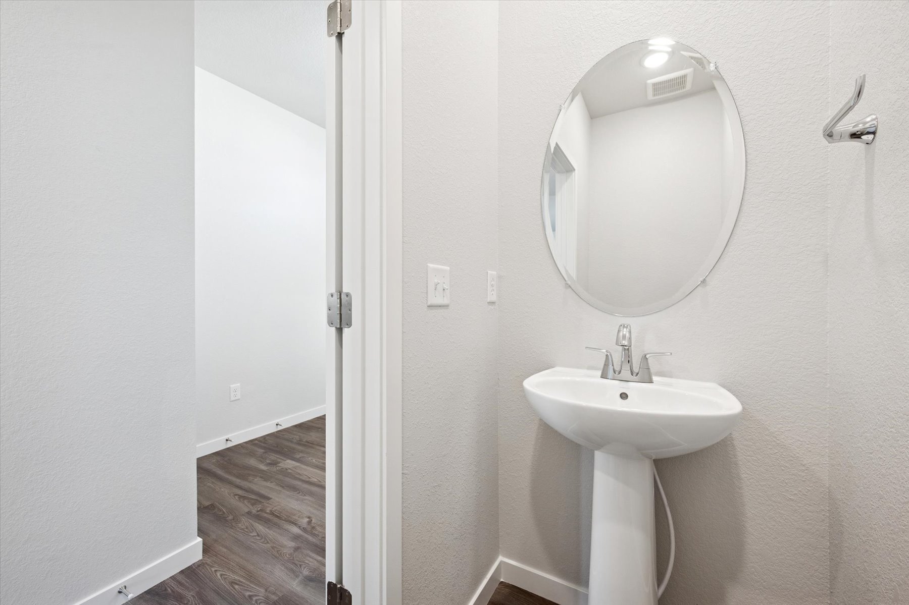 A bathroom with a round mirror.
