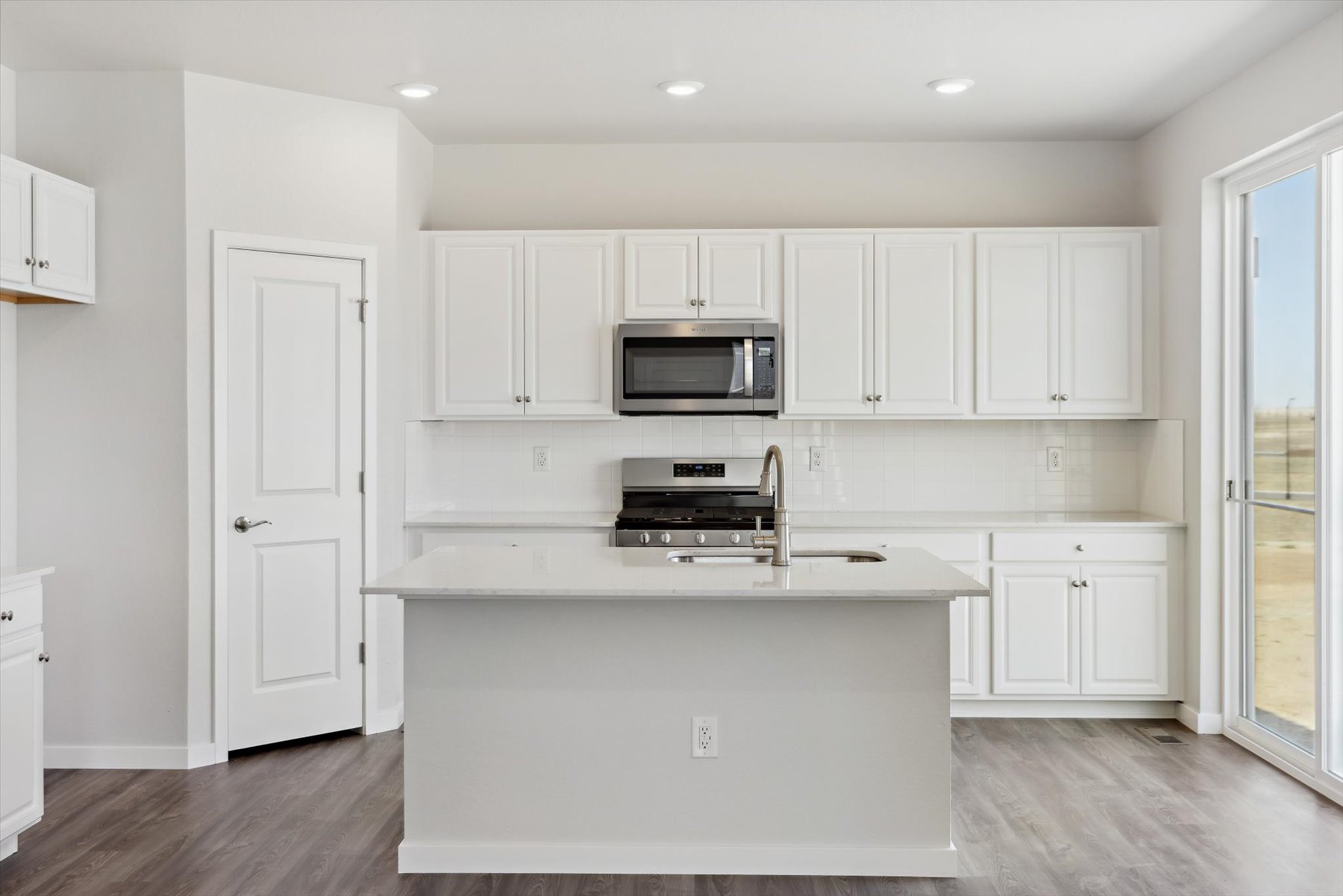 A kitchen with white cabinets.