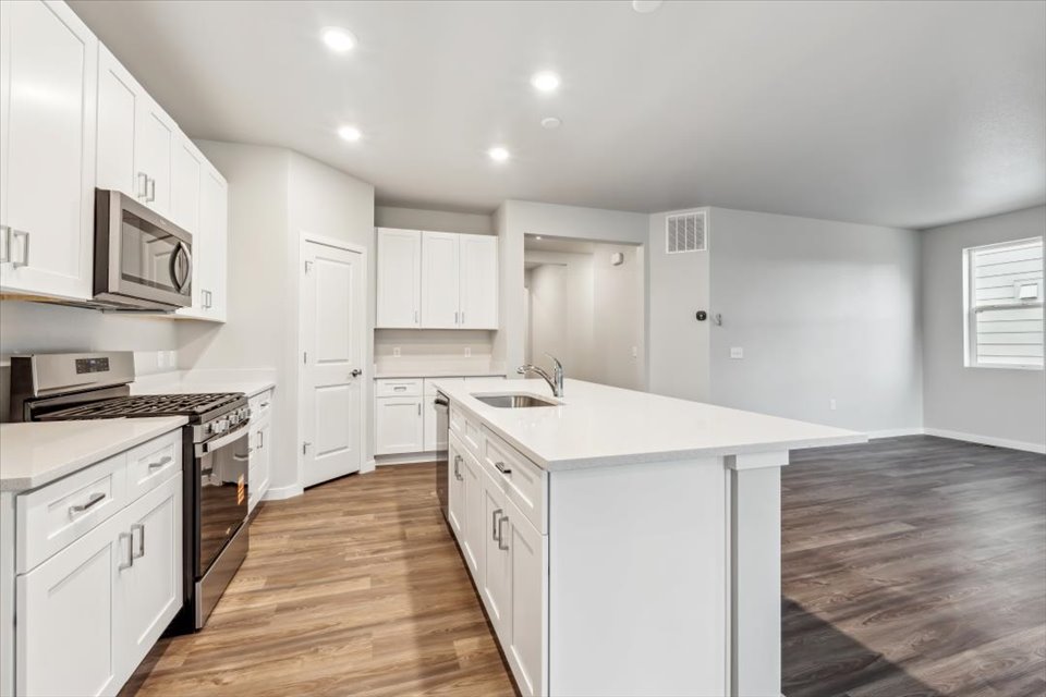 A kitchen with white cabinets.