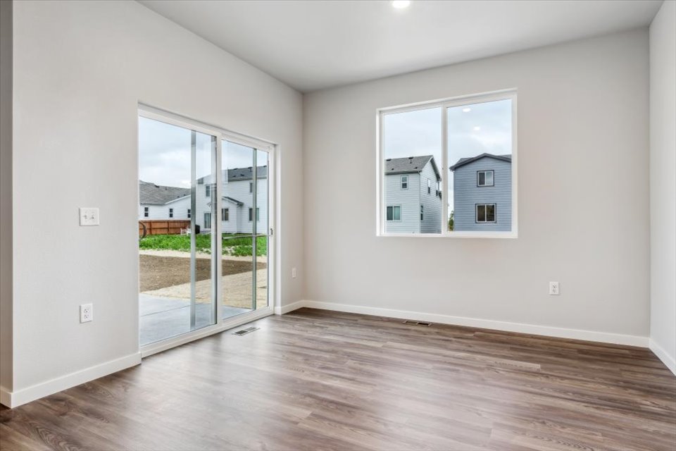 A room with a wood floor and a large window.
