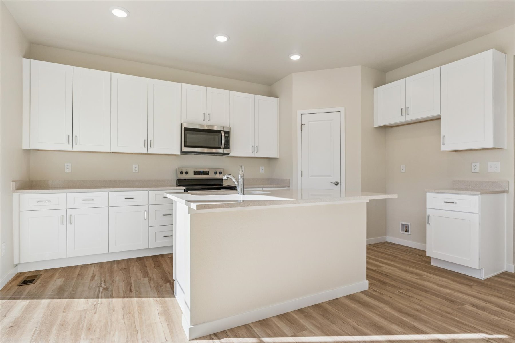 A kitchen with white cabinets.