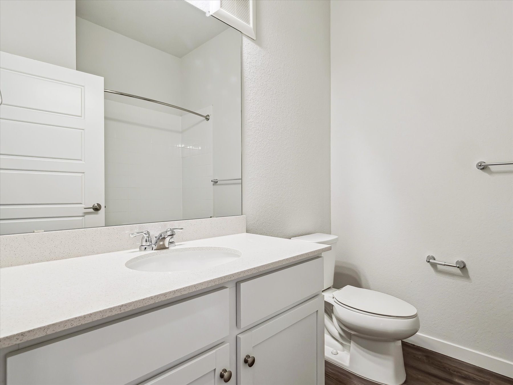 A bathroom with a sink toilet and mirror.