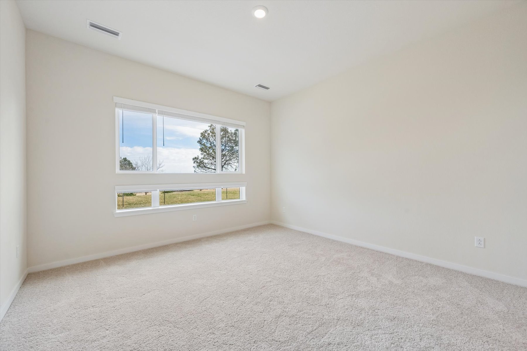 A room with a window and a carpet.