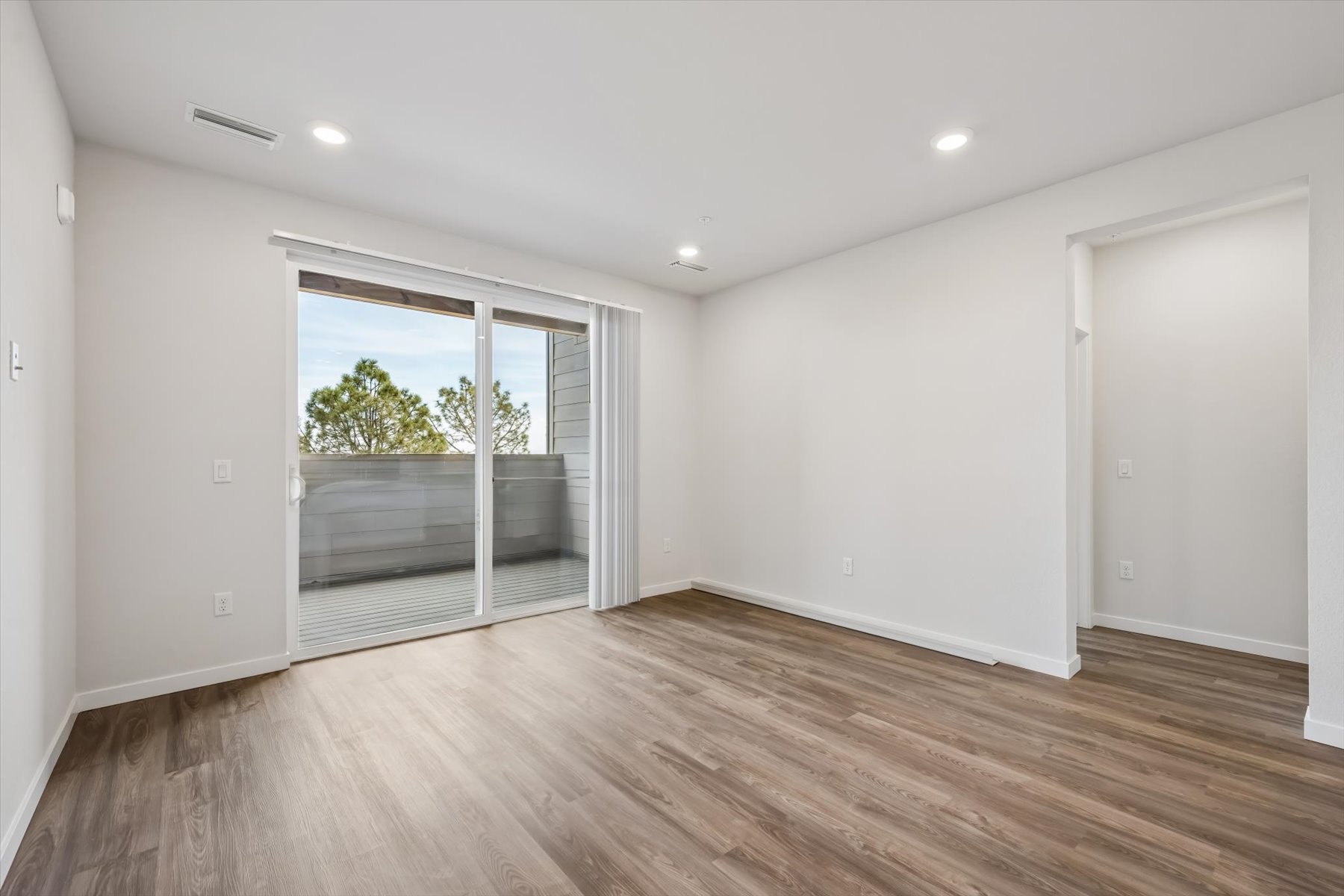 A room with a wood floor and a wood floor with a window.