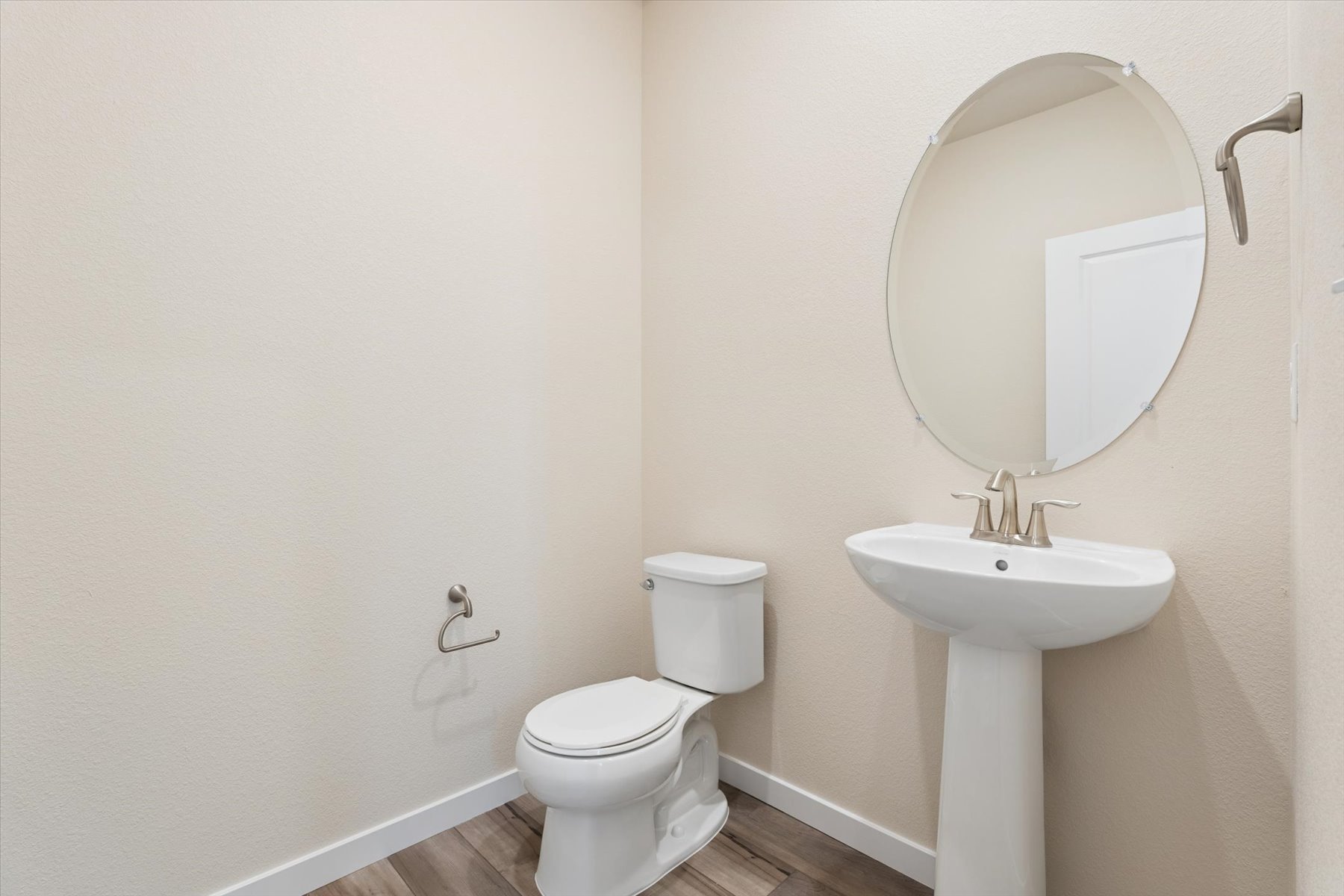 A bathroom with a round mirror.