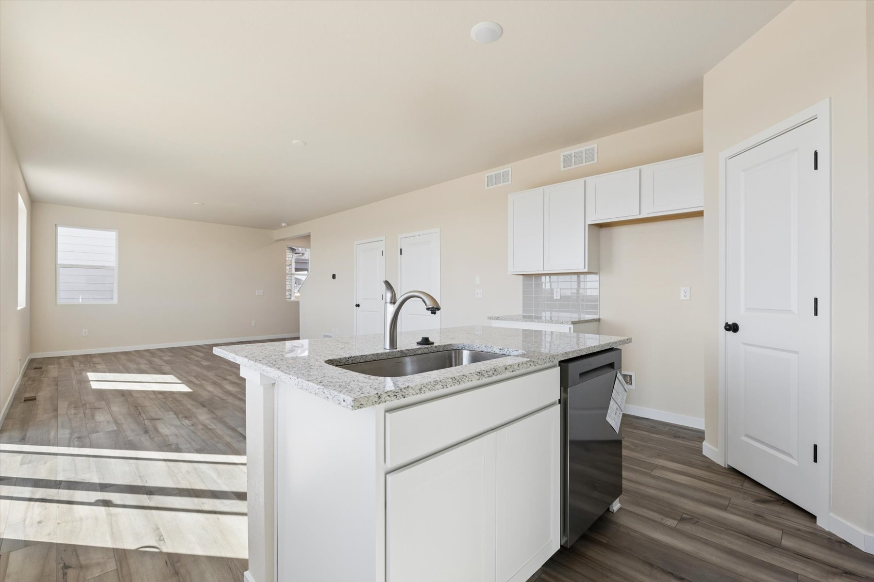 A kitchen with white cabinets.