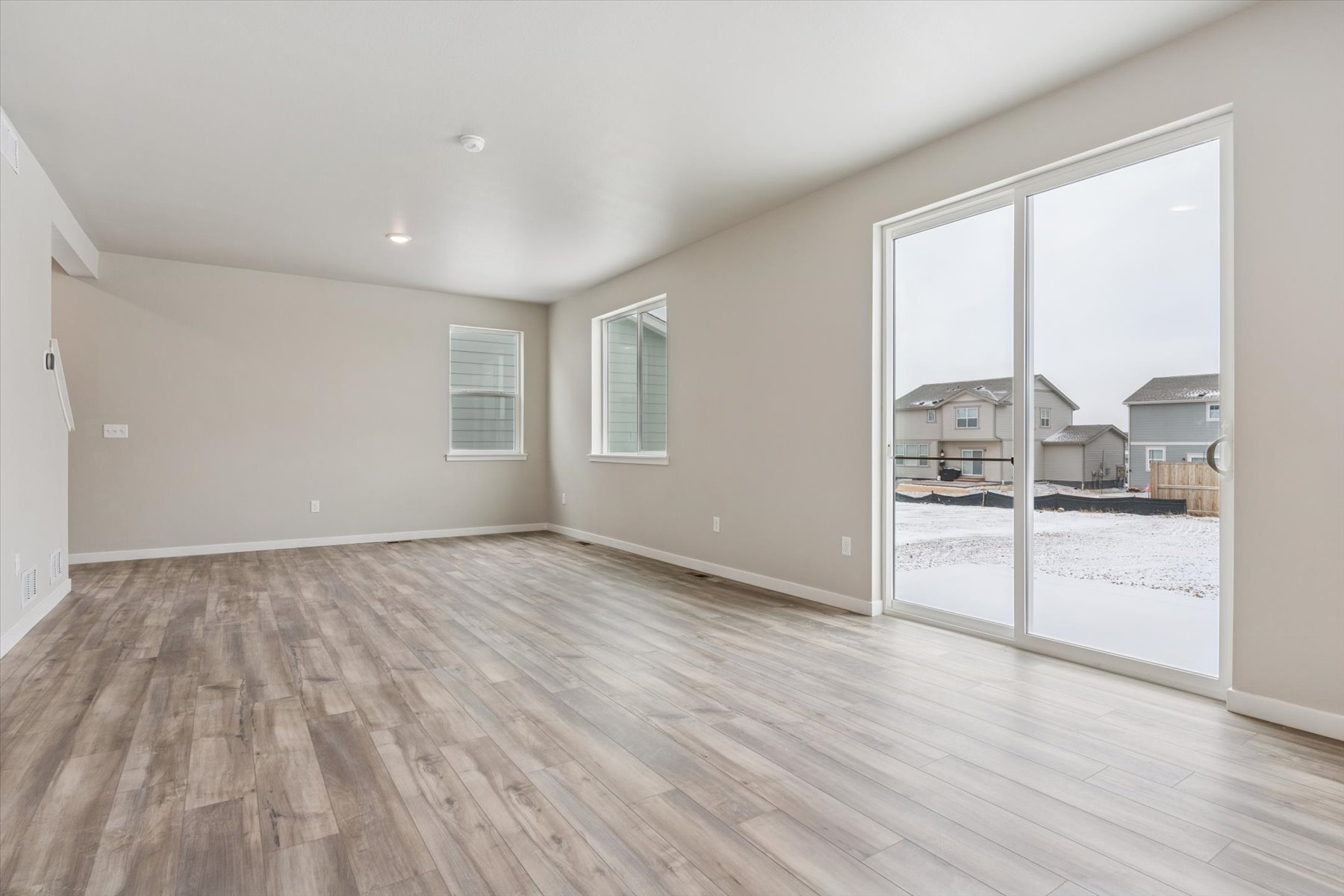 A room with a wood floor and a wood floor with a window.