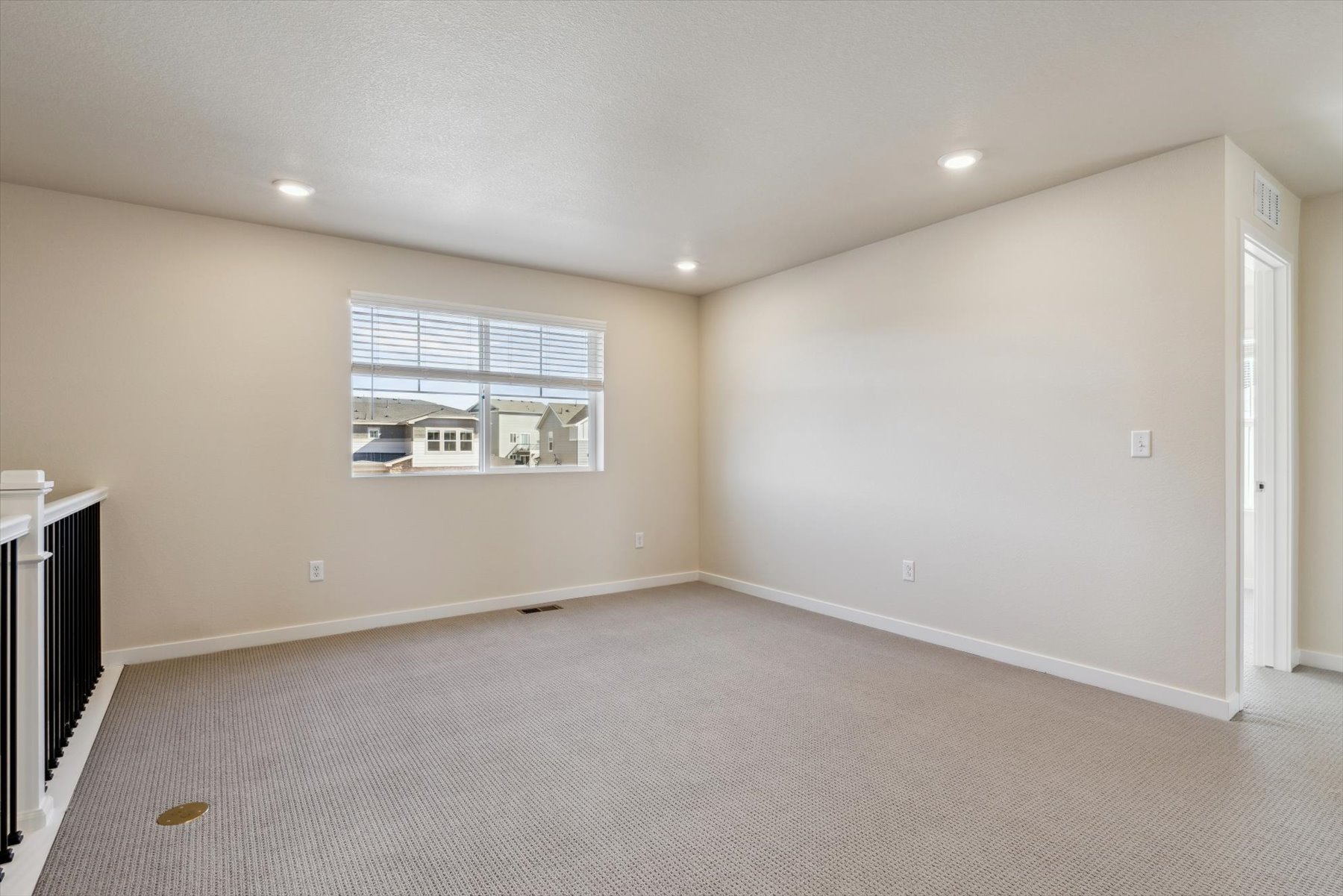 A room with a white carpet and a window.