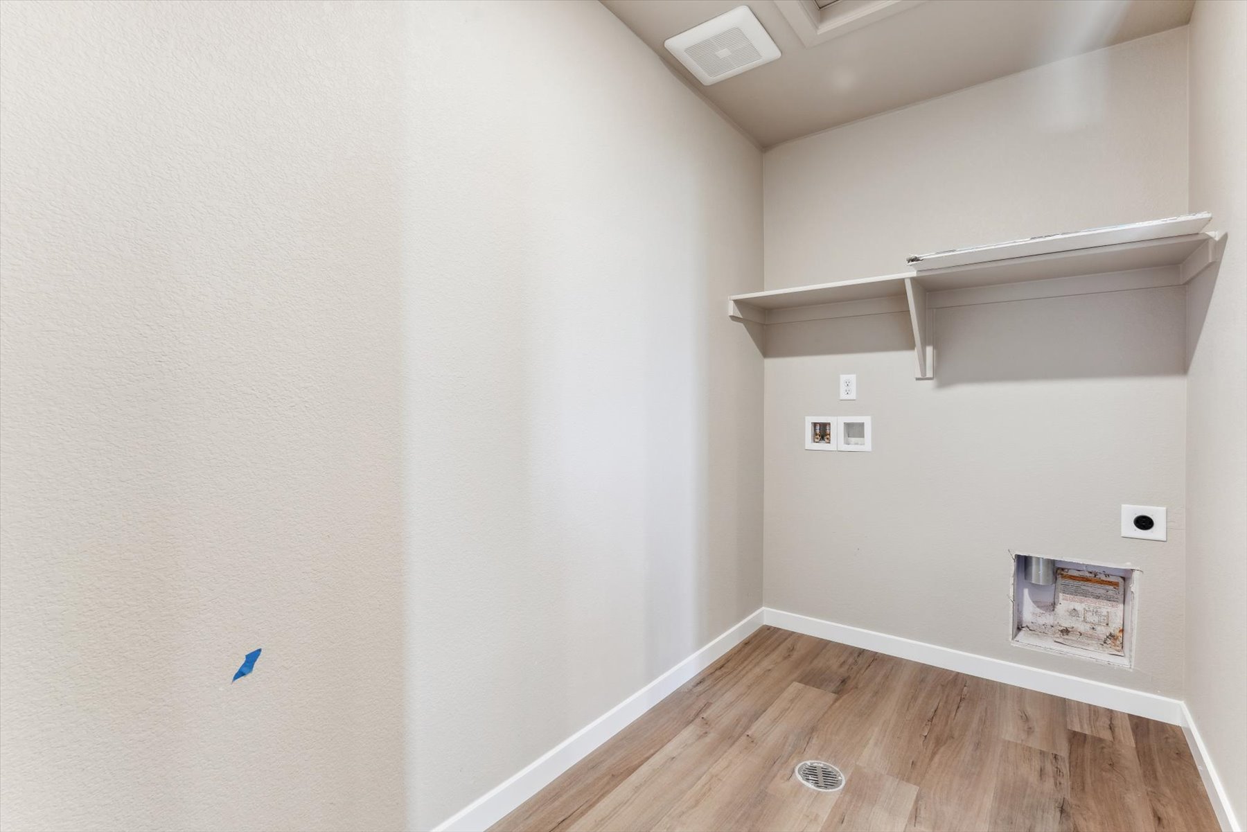 A room with a wood floor and a white wall with a wood floor.