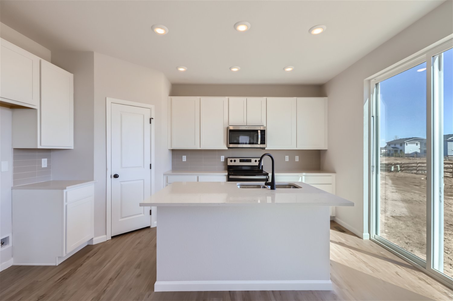 A kitchen with white cabinets.