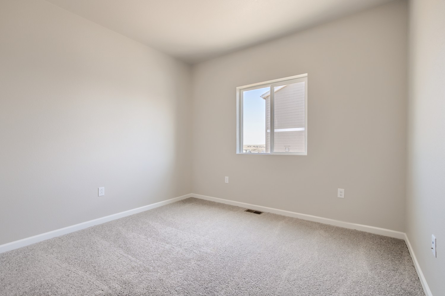 A room with a window and carpet.