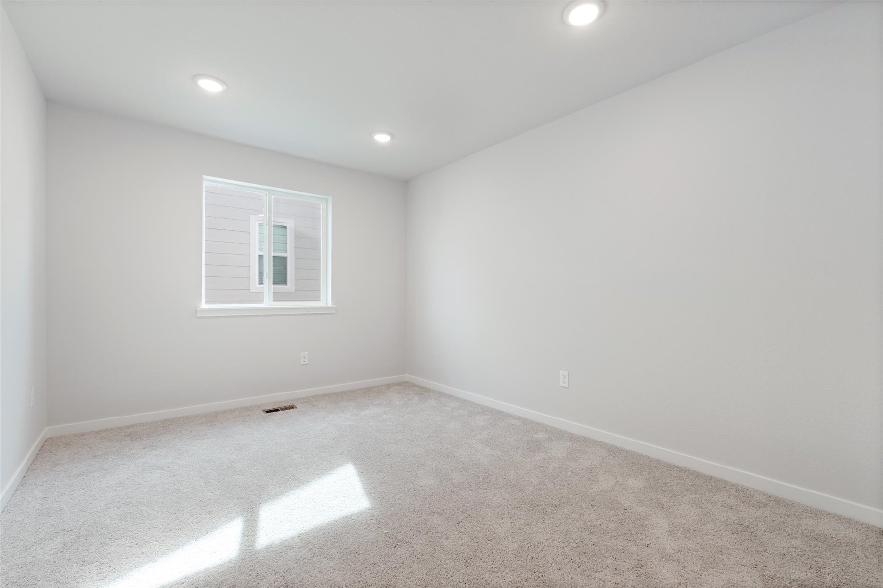 A room with a window and a carpet.