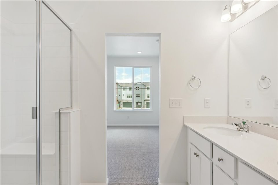 A bathroom with a sink and a shower unit.