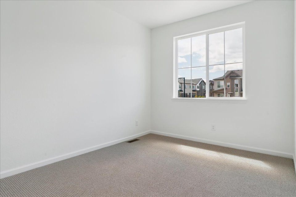 A room with a window and a carpet.