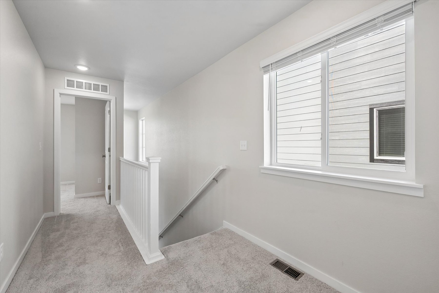 A room with a window and a staircase.