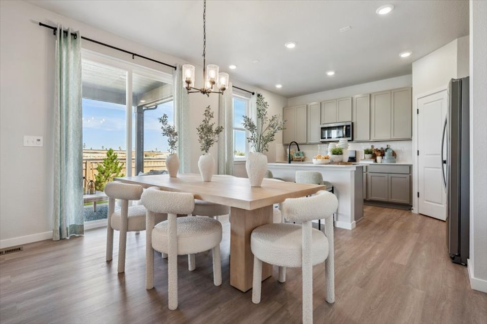 A kitchen with a dining table and chairs.