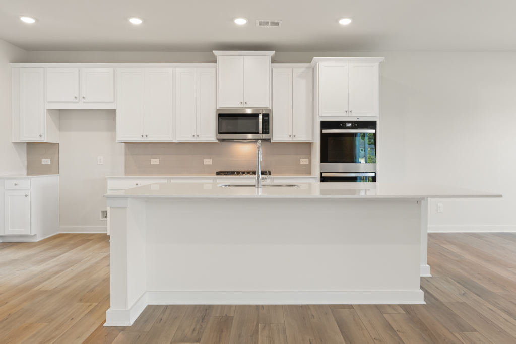A kitchen with white cabinets.