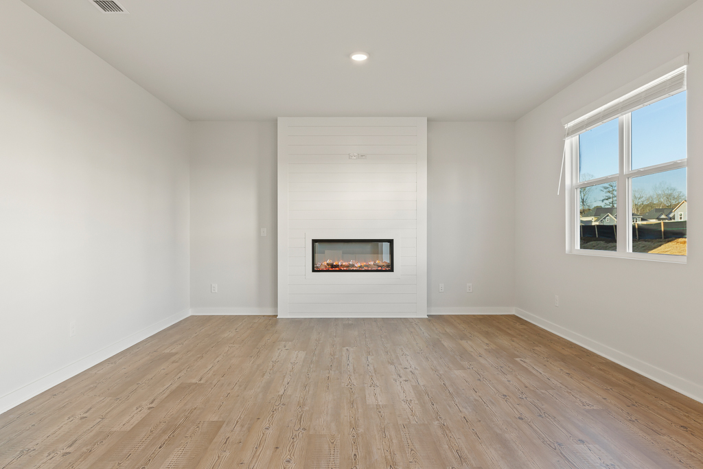 A room with a fireplace and a wood floor.