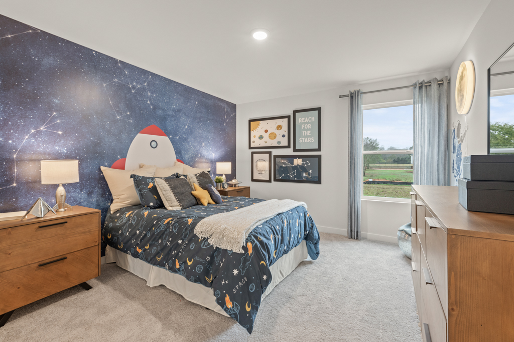 A bedroom with a bed and a cartoon character on the wall.