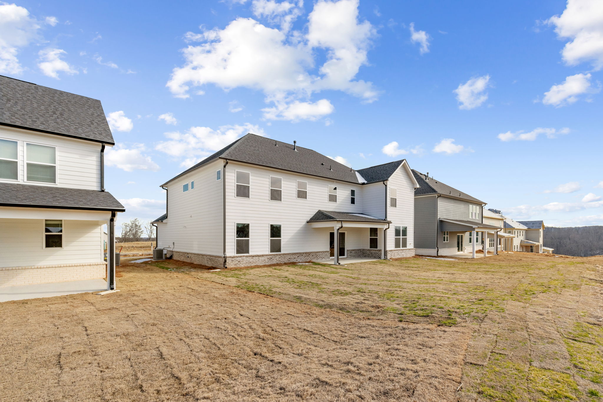 A dirt road leading to a row of houses.