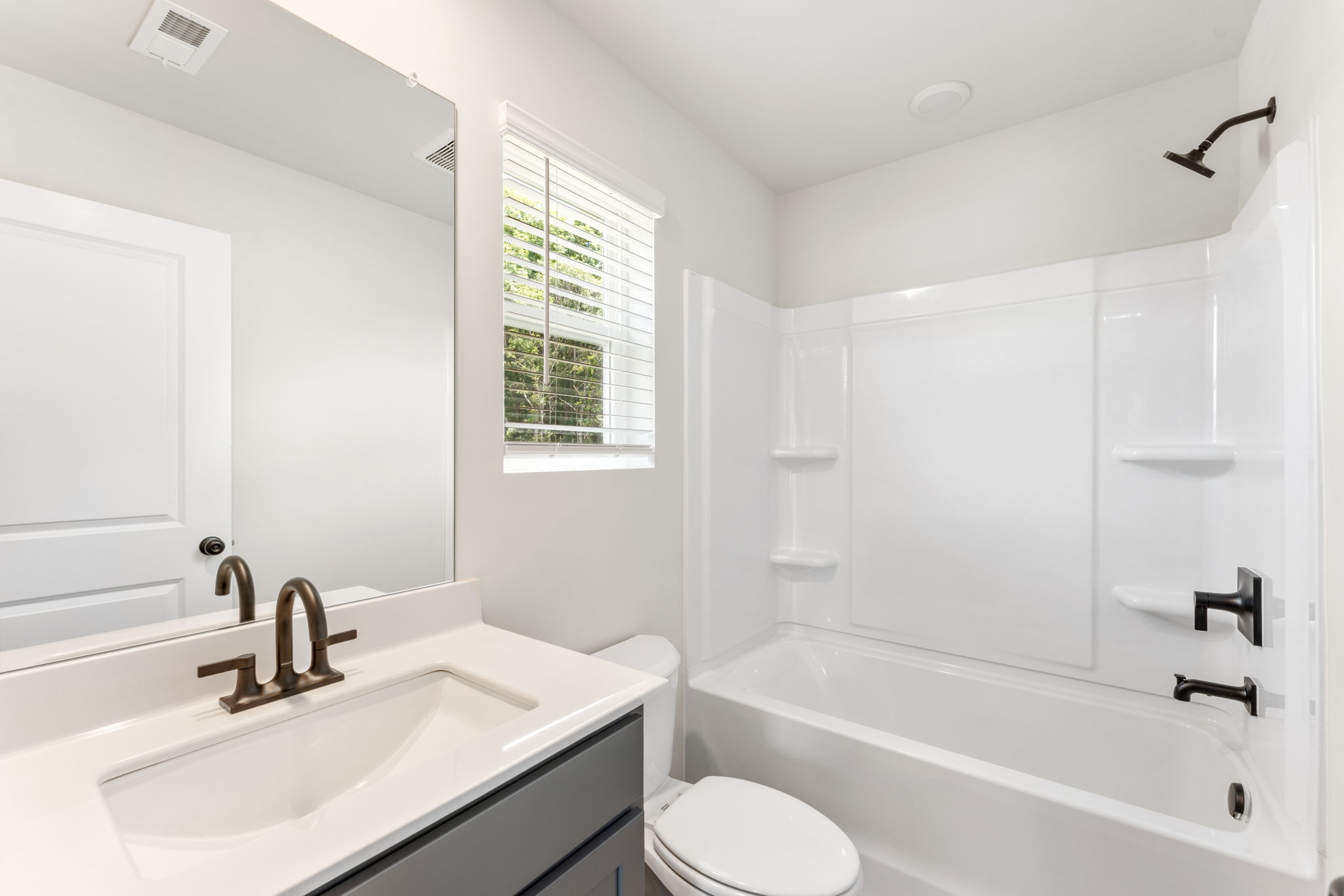 A bathroom with a tub sink and toilet.