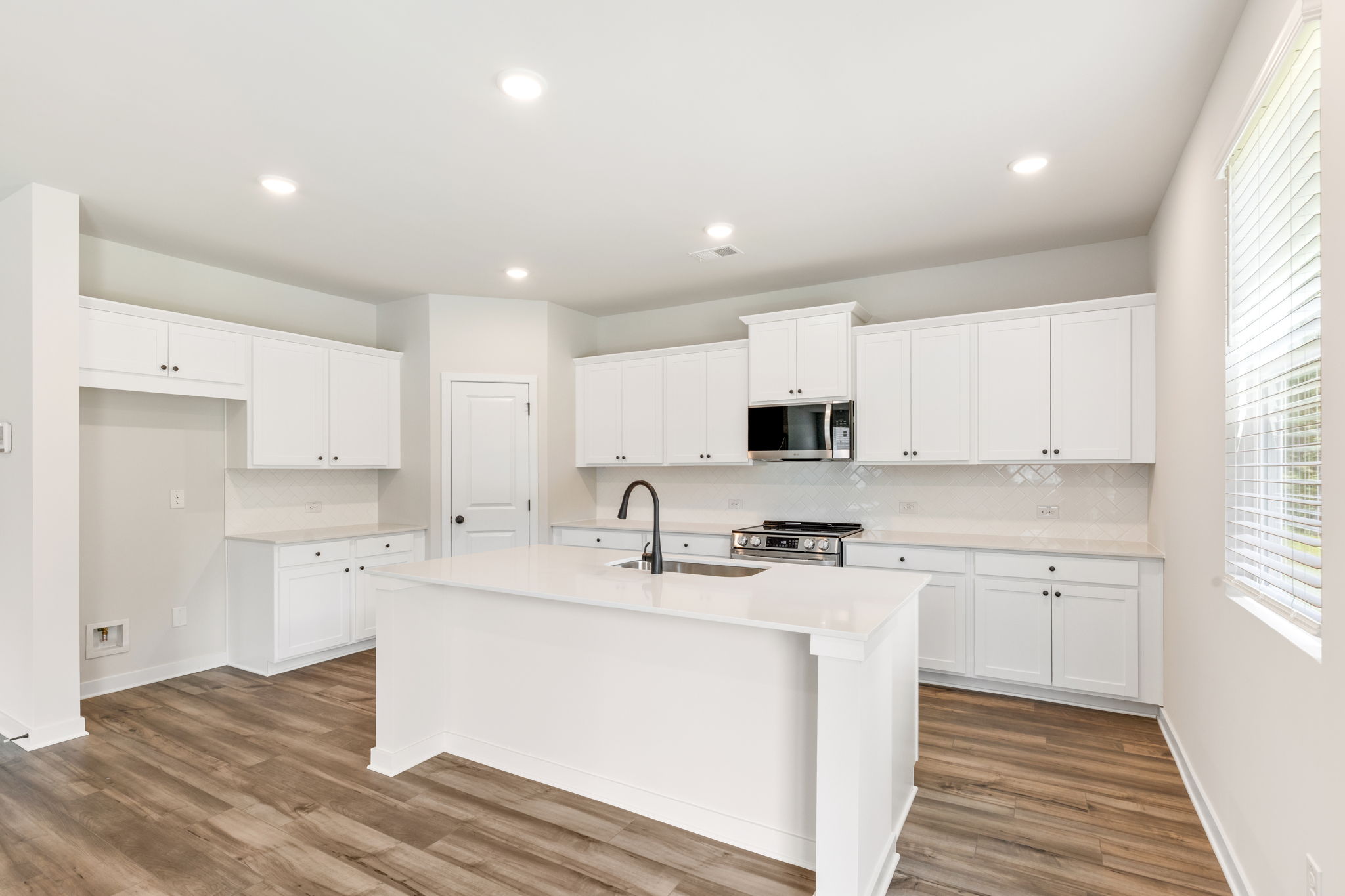 A kitchen with white cabinets.