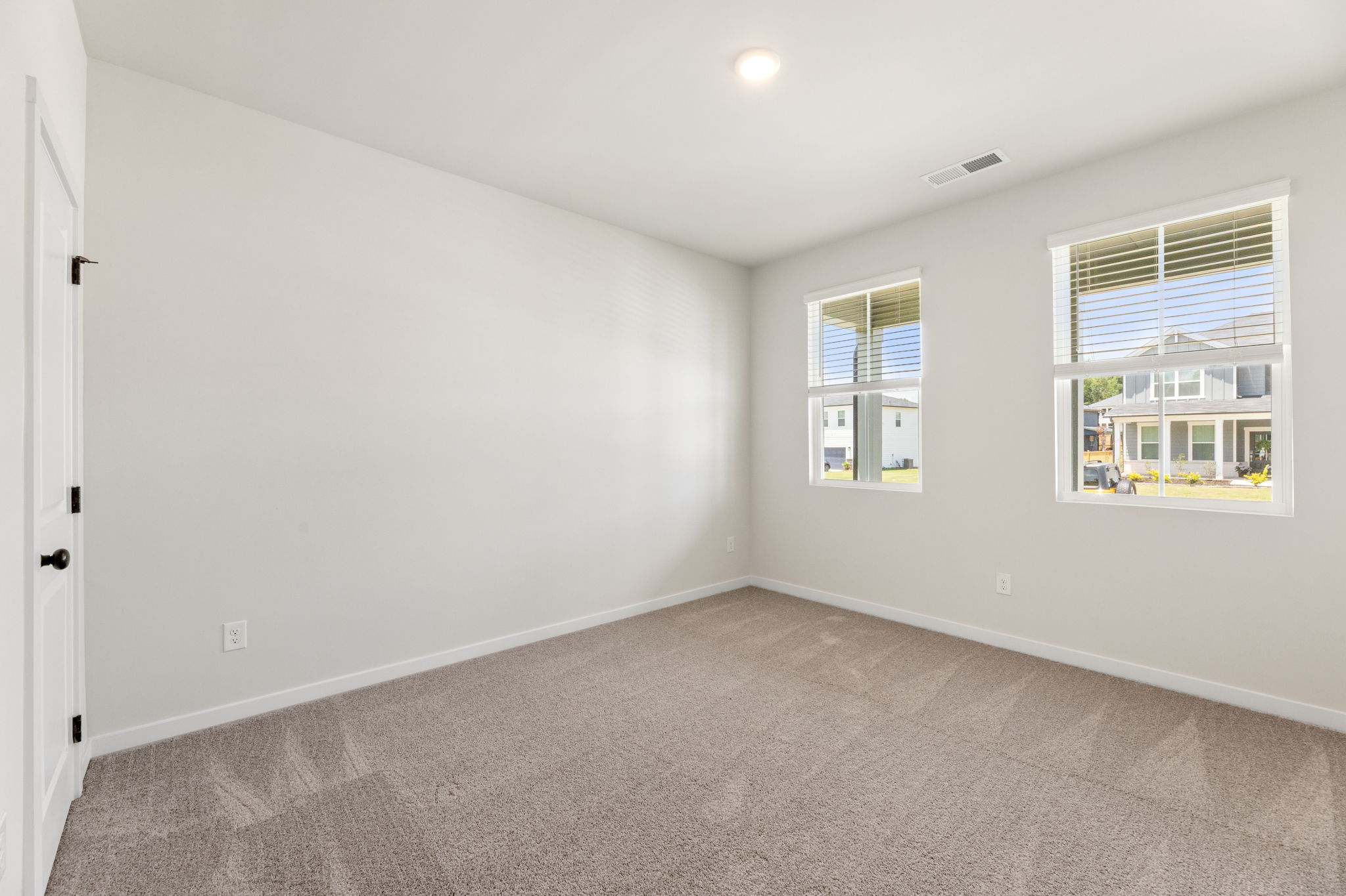 A room with windows and a carpet.