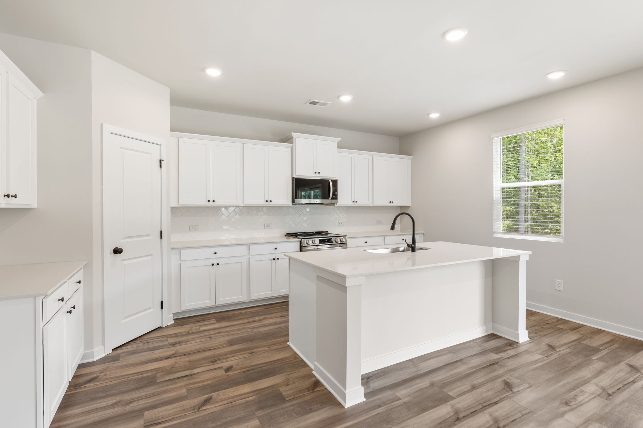 A kitchen with white cabinets.