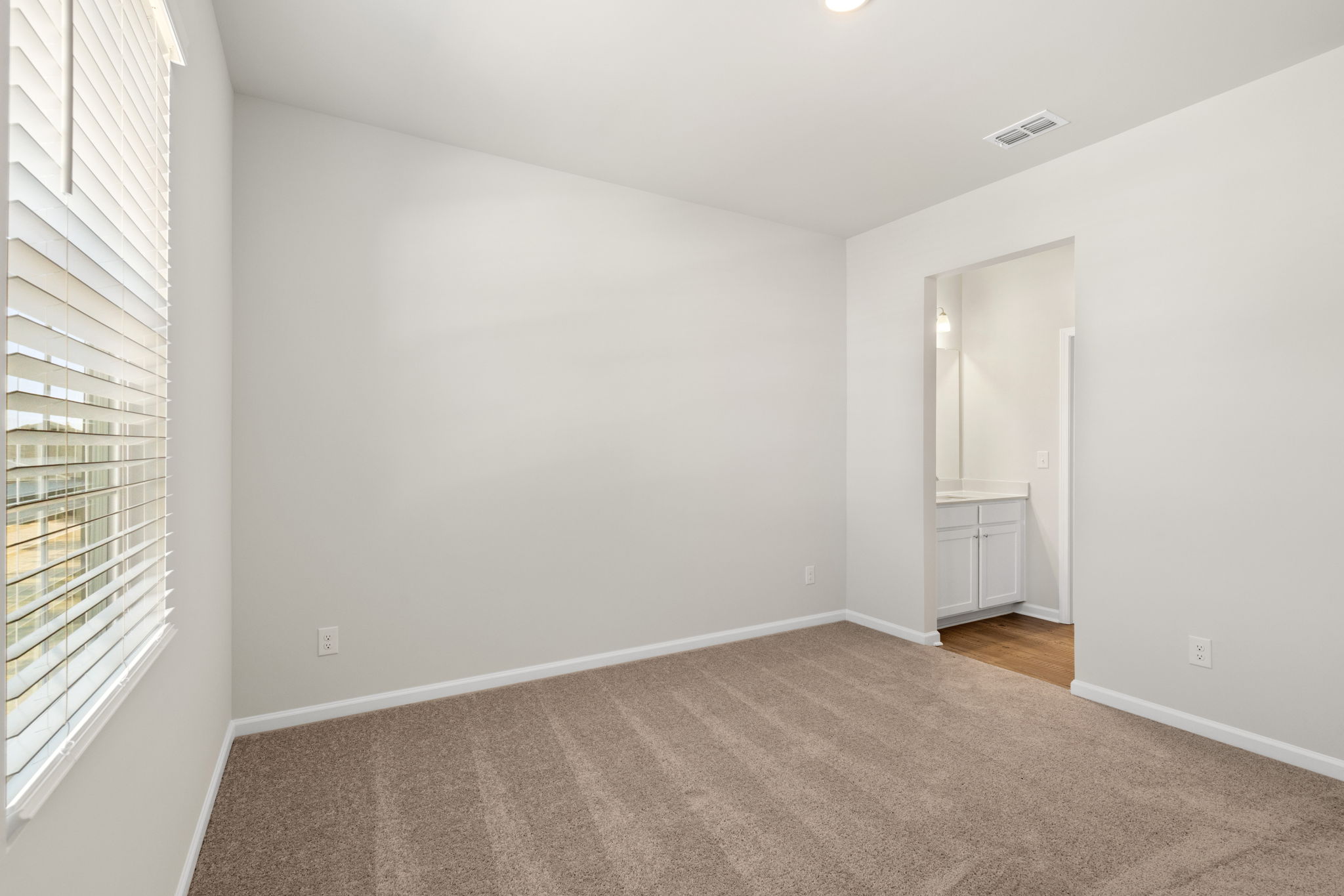 A room with a carpet and a window.