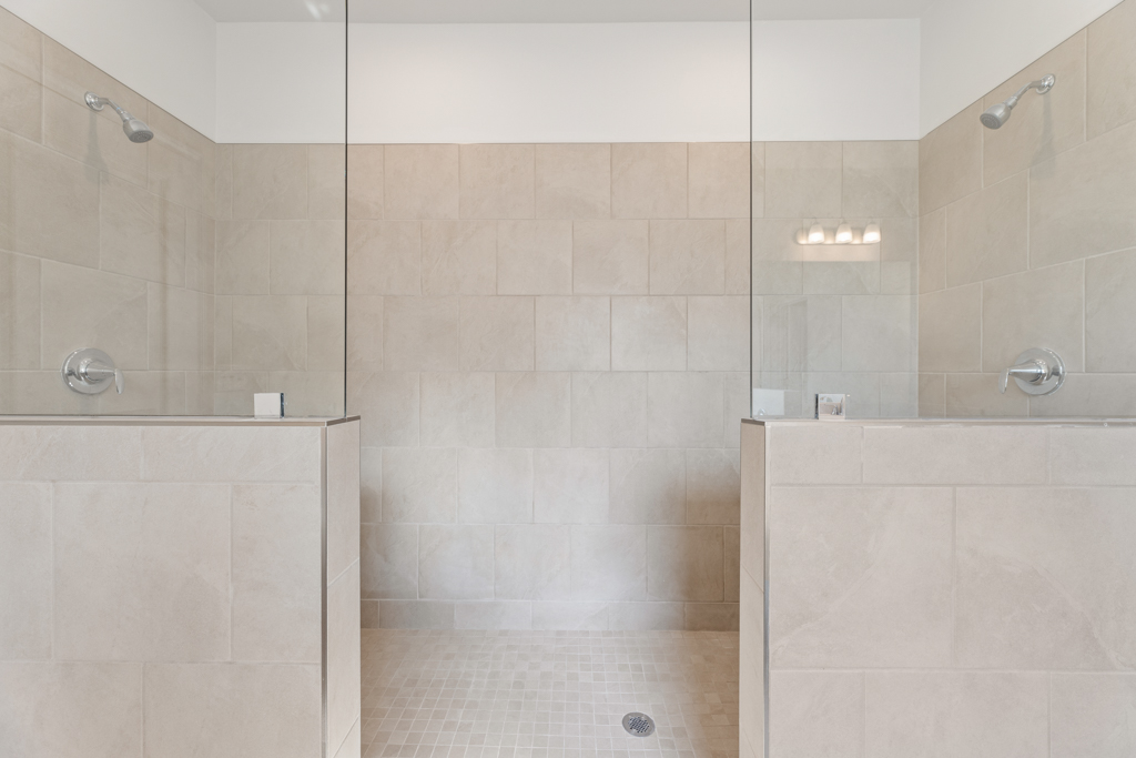 A bathroom with a shower unit and a toilet.