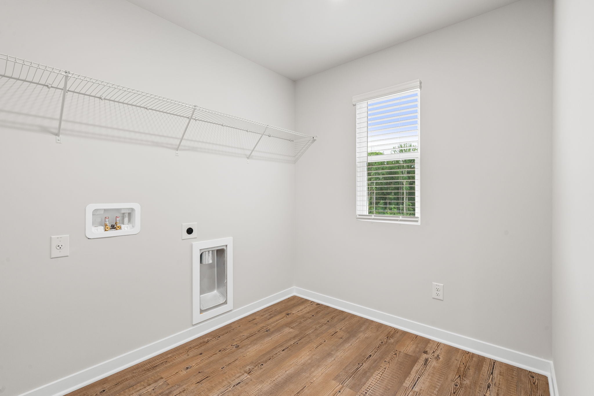A room with a wood floor and a window.