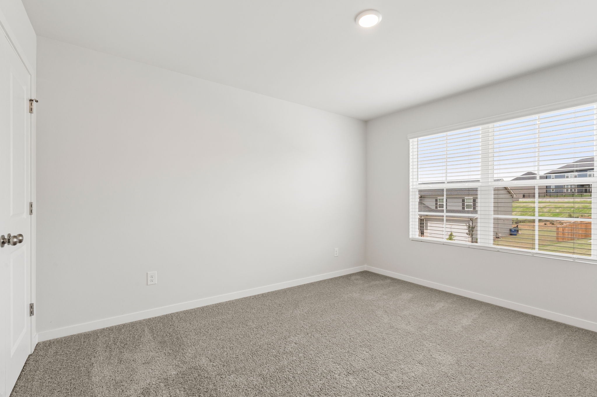 A room with a window and a carpet.