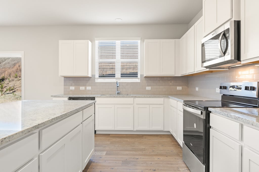 A kitchen with white cabinets.