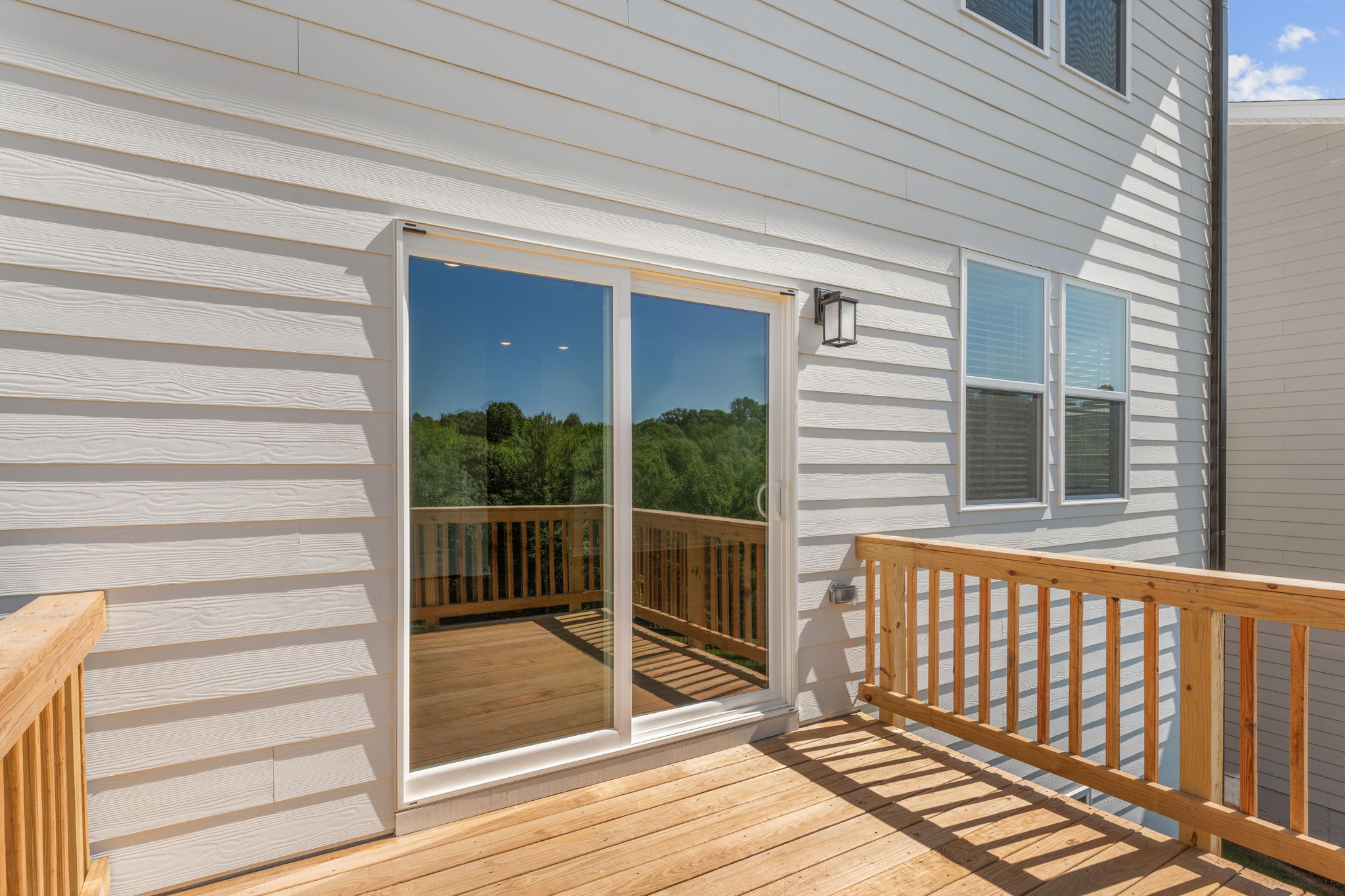 A porch with a wood railing and a wood railing.